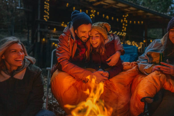 istock Young couple sitting by campfire 1251323336