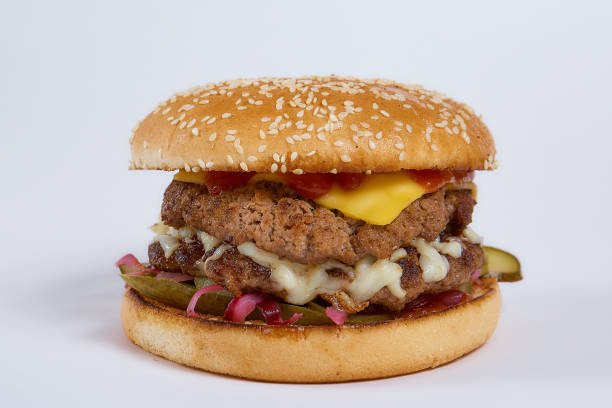 istock Juicy burger with cucumbers, lettuce, cheese on a white background 1251323496