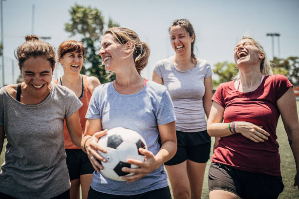 Female soccer players enjoying time together outdoors on soccer field Group of women, female soccer players, enjoying time together outdoors on soccer field. football player girlfriend stock pictures, royalty-free photos & images