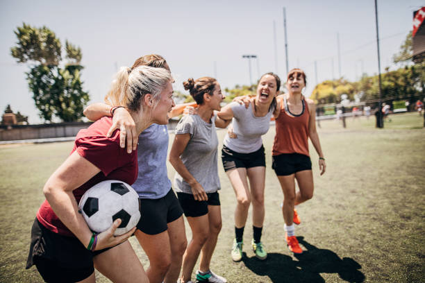 Female soccer players enjoying time together outdoors Group of women, female soccer players, enjoying time together outdoors on soccer field. football player girlfriend stock pictures, royalty-free photos & images