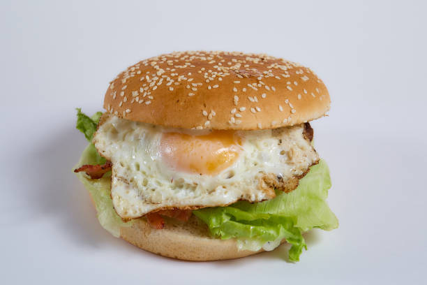 Juicy burger with onion rings, jalapeno pepper, cucumbers, lettuce, cheese on a white background. High quality photo