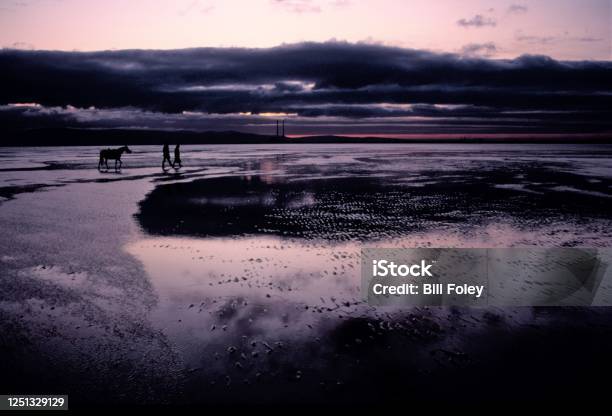 Dollymount Strand Dublin Ireland At Sunset Stock Photo - Download Image Now - Couple - Relationship, Dramatic Sky, Horizontal