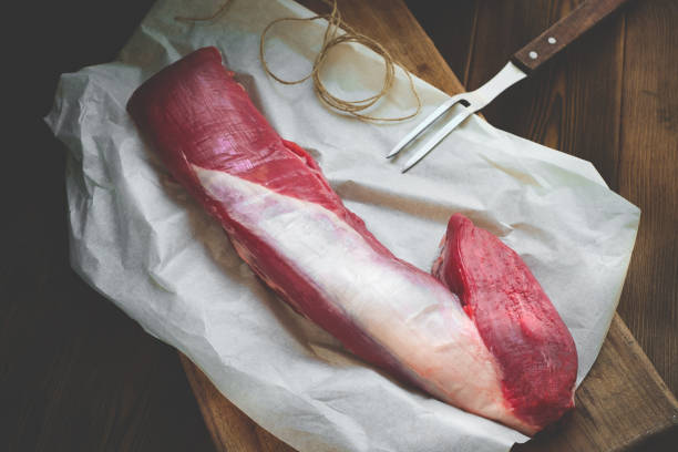 raw whole tenderloin of beef black Angus at the butcher shop on Kraft paper on a wooden Board