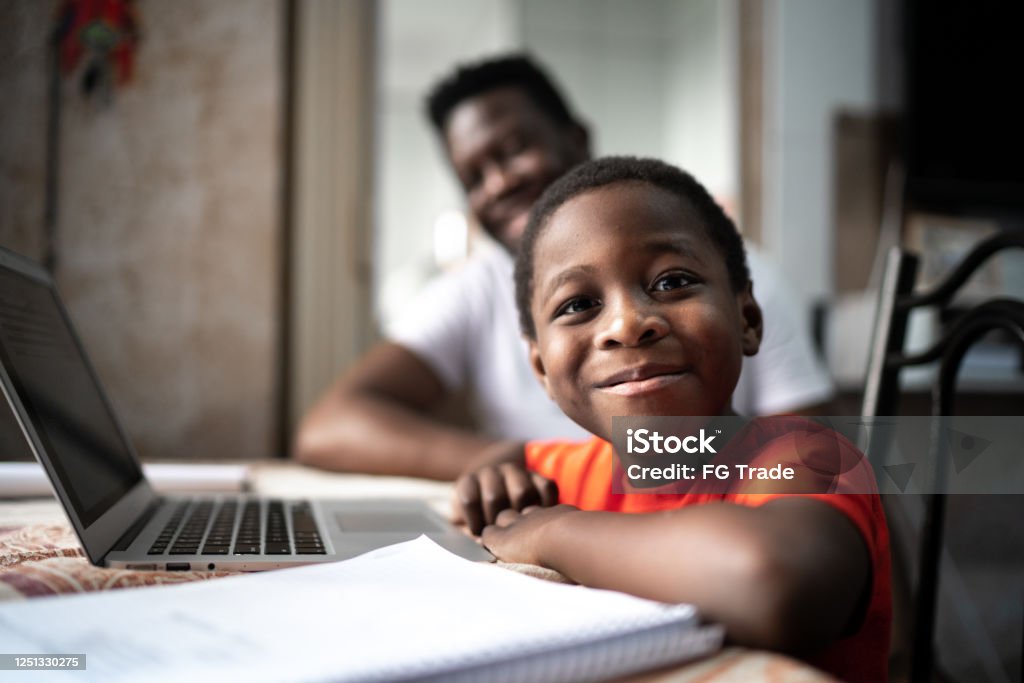 Portrait of father and son studying with laptop on a online class at home Child Stock Photo