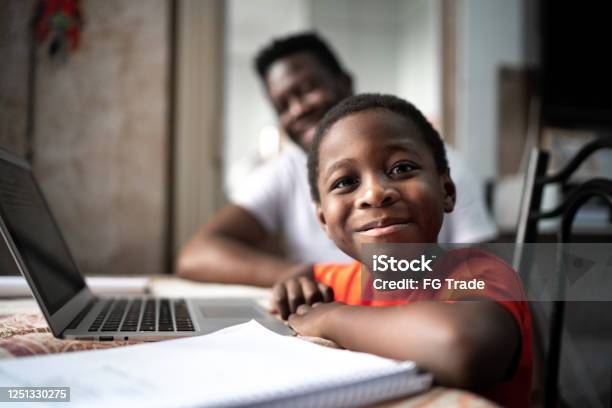 Portrait Of Father And Son Studying With Laptop On A Online Class At Home Stock Photo - Download Image Now
