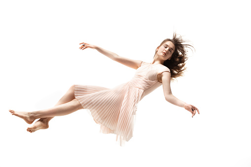 Mid-air beauty cought in moment. Full length shot of attractive young woman hovering in air and keeping eyes closed. Levitating in free falling, lack of gravity. Freedom, emotions, artwork concept.