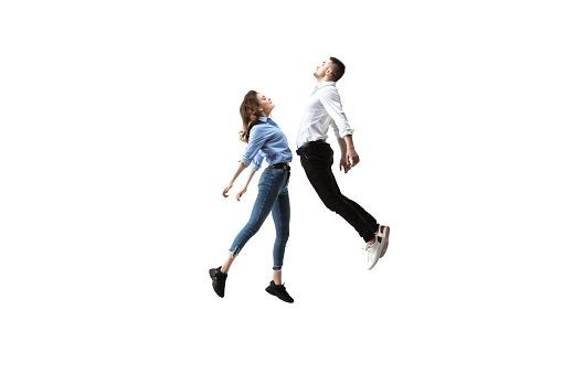 Mid-air beauty cought in moment. Full length shot of attractive young woman and man hovering in air and keeping eyes closed. Levitating in free falling, lack of gravity. Freedom, emotions, artwork concept.