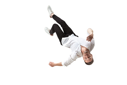 Mid-air beauty cought in moment. Full length shot of young man hovering in air and keeping eyes closed. Levitating in free falling, lack of gravity, flying. Freedom, emotions, artwork concept.