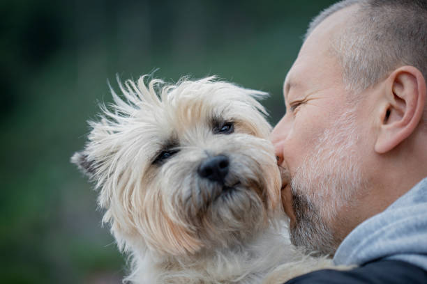 istock Mature man kisses his dog 1251331738