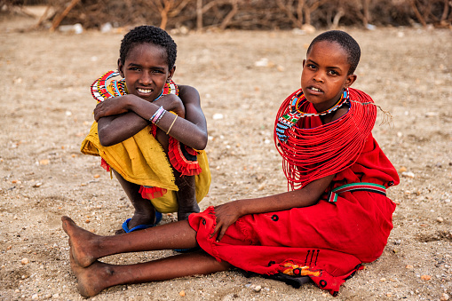 Two African little girls from Samburu tribe, resting on savanna. Samburu tribe is one of the biggest tribes of north-central Kenya, and they are related to the Maasai.