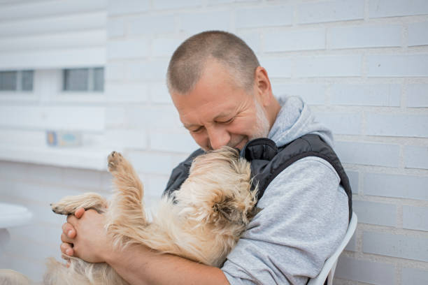 istock Mature man kissing his dog 1251331765