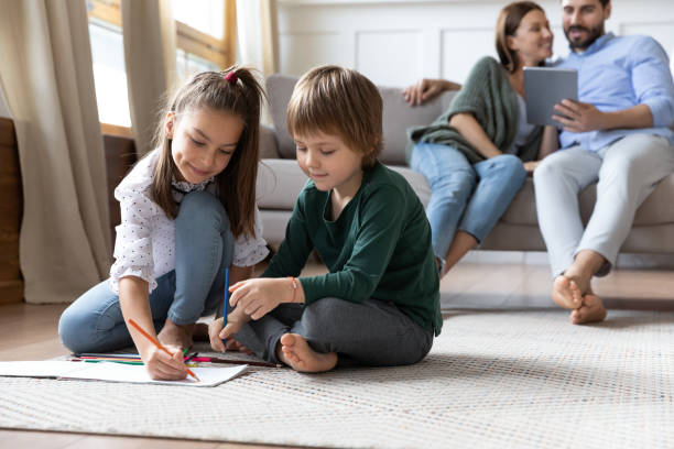 istock Children playing on warm floor while parents relaxing on couch 1251332274