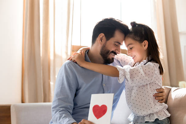 istock Pretty girl touching foreheads with father, congratulating, presenting gift 1251332373