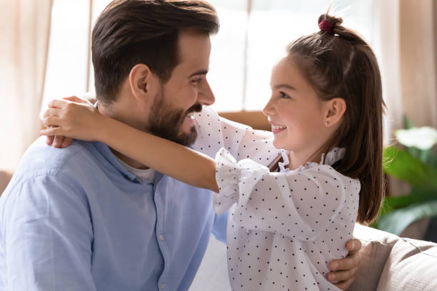 istock Close up smiling father and daughter hugging, looking in eyes 1251332375
