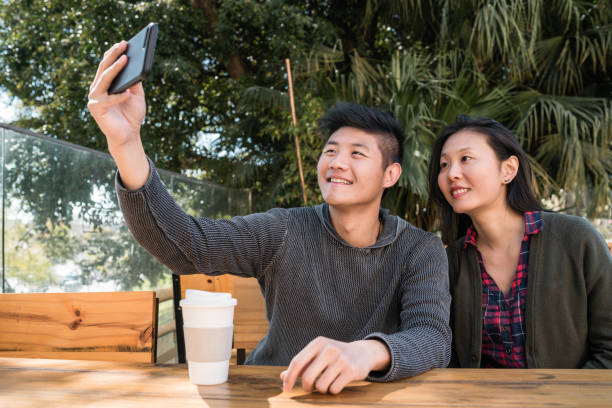 istock Asian couple taking a selfie with mobile phone. 1251333107