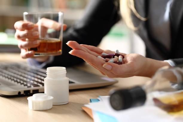 entrepreneur hands attempting suicide with pills and alcohol at homeoffice - alcohol drug abuse alcoholism pill imagens e fotografias de stock