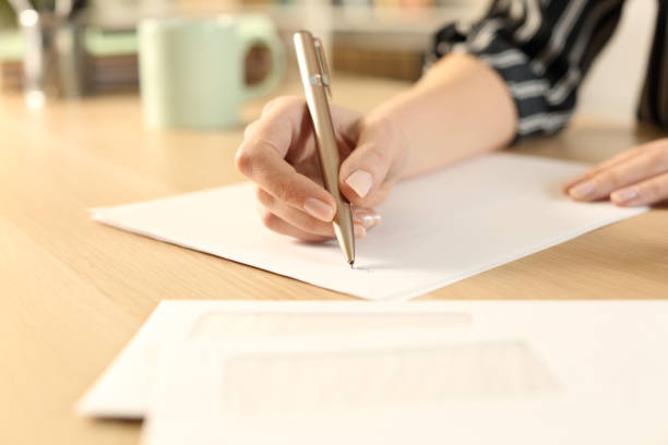 istock Woman hands writing letter sitting on a desk 1251333781