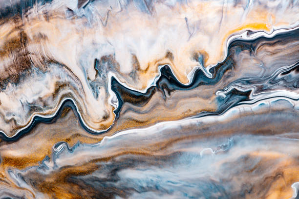 Fluid art texture. Background with abstract mixing paint effect. Liquid acrylic picture with flows and splashes. Mixed paints for baner or wallpaper. Brown, golden and navy blue overflowing colors.