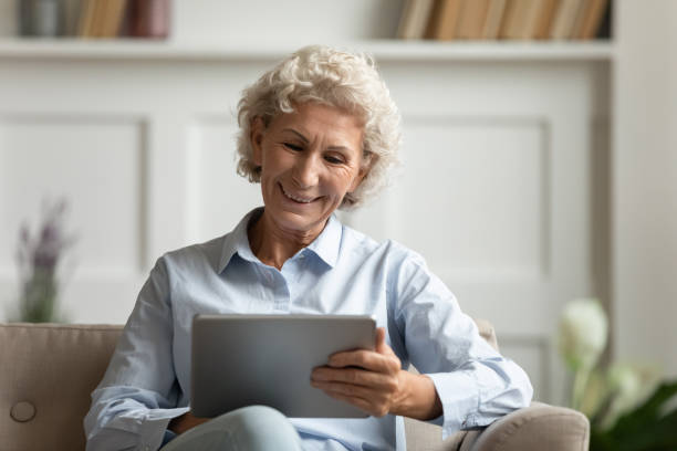 istock Aged woman using tablet websurfing chatting with friends using messenger 1251337462