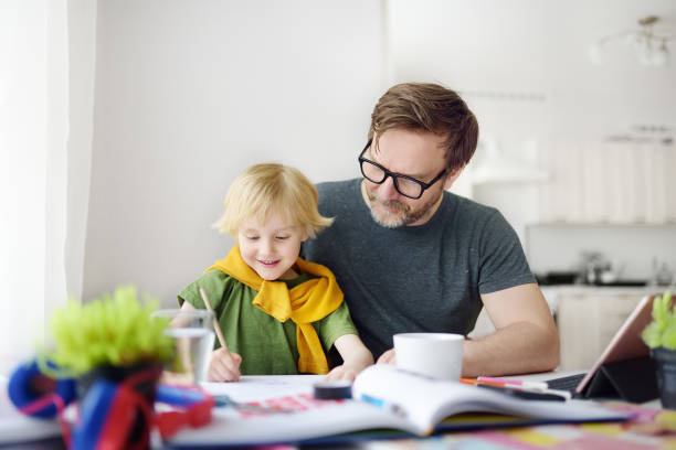 istock Father helping child do his homework at home. Homeschooling, distance learning, online studying, remote education for kids during quarantine is a problems for parents. Tutor teaching boy with ADHD. 1251338468
