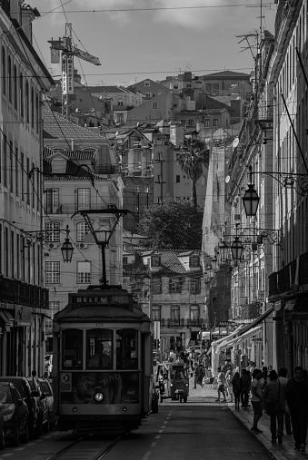 A black and white picture of a tram in the old town of Lisbon.