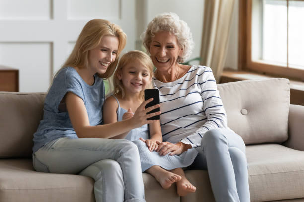 istock Multi-generational women family sit on sofa using smartphone 1251339061