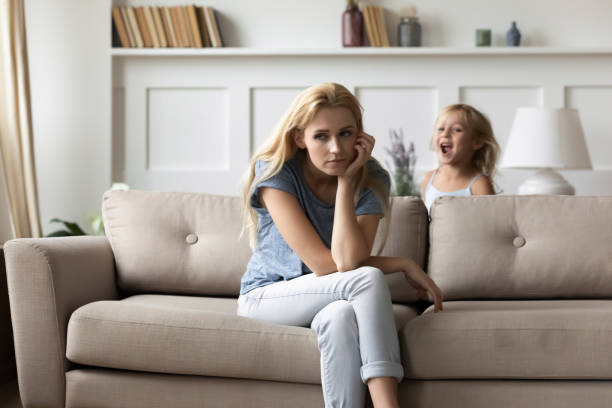 istock Tired mom feels tired of hyperactive noisy disobedient daughter 1251339080