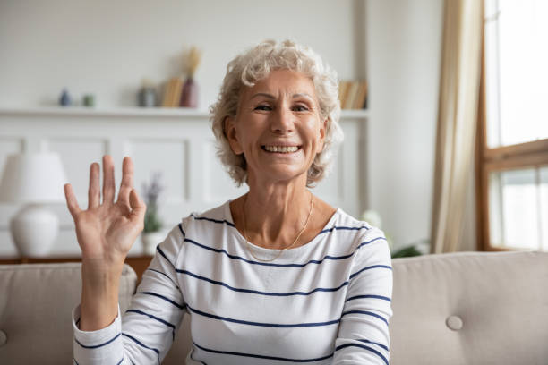 istock Mature woman greeting friend start videoconferencing virtual communication webcam view 1251339169