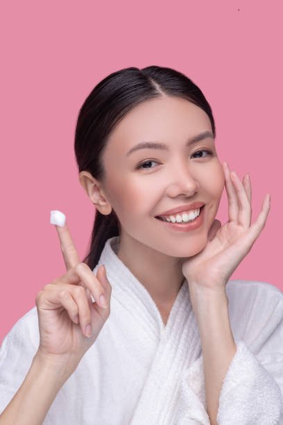 istock Woman using moisturising cream for her face 1251340276
