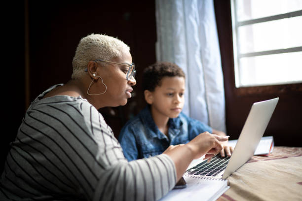 istock Mother and son studying with laptop at home 1251340328
