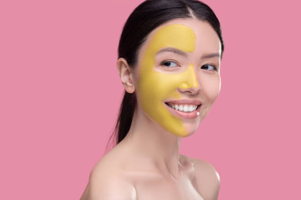 istock Smiling woman having a beauty mask on her face 1251340409