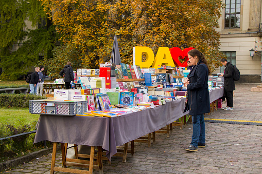 Berlin, Germany - October 14, 2017: Flea market in Berlin center. Books sale. Young woman bay books.