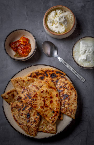 istock Aloo paratha or stuffed potato flatbread with curd, white butter and mango pickles 1251340863