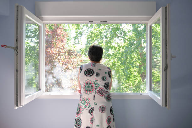 istock Woman looking through the opened window 1251341463