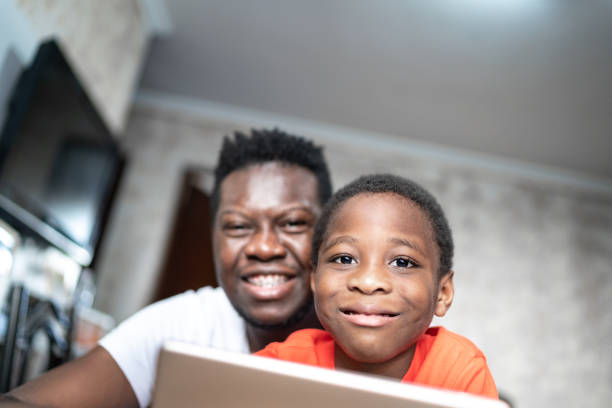 istock Portrait of father and son using digital tablet at home 1251341532