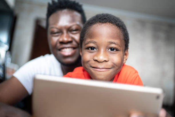 istock Portrait of father and son using digital tablet at home 1251341533