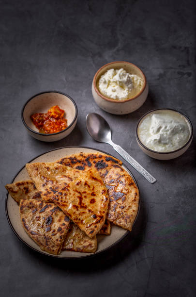 istock Aloo paratha or stuffed potato flatbread with curd, white butter and mango pickles 1251342017