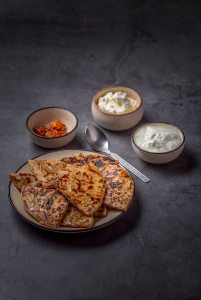 istock Aloo paratha or stuffed potato flatbread with curd, white butter and mango pickles 1251342151