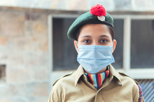 Indian A young girl in NCC uniform and wearing protective mask. during covid 19 pandemic. outdoor shoot at home balcony. copy space.