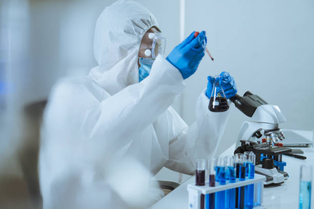 istock Young man scientist drop and shake biochemical in Erlenmeyer Flask for mixing and looking in laboratory. Doctor and scientist work in laboratory pandemic of corona virus, COVID19 concept 1251343489