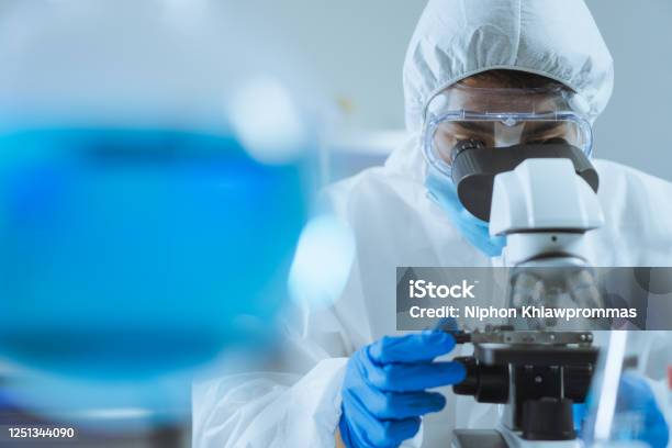 Young Asian Handsome Man Scientist Adjust Focus And Use Microscope To Looking Biochemical Cell In Laboratory Doctor And Scientist Work In Laboratory Pandemic Of Corona Virus Covid19 Concept Stock Photo - Download Image Now