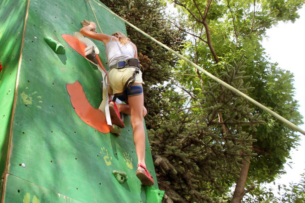istock girl climbs a climbing wall in the park 1251345077