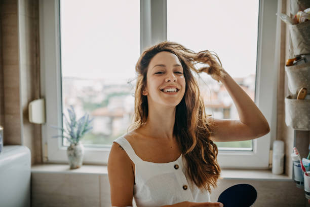 mujer joven peinando el cabello - hair care combing women human hair fotografías e imágenes de stock