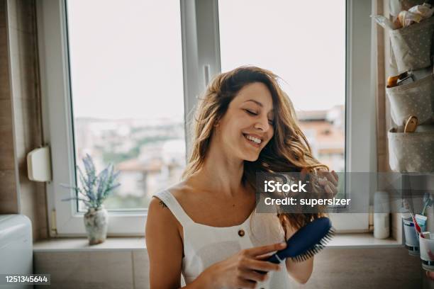 Young Woman Combing Hair Stock Photo - Download Image Now - Women, One Woman Only, Human Hair