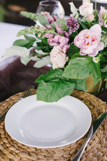 istock Table setting for a romantic dinner. Beautiful flowers in a vase on the table 1251345705