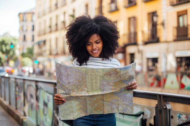 istock Beautiful Afro tourist exploring the city map 1251345833