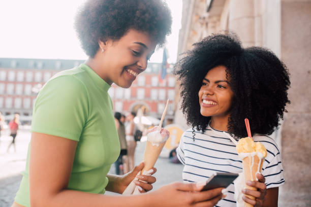 istock Girls eating ice cream and having fun using smartphone 1251346039