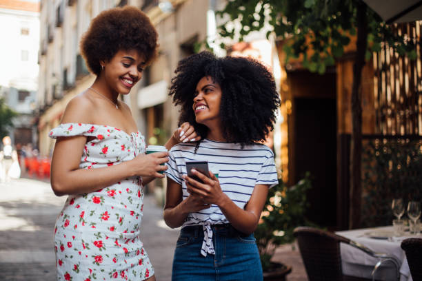 istock Two girls using smartphone and having fun in the city 1251346338