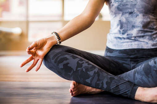 Woman meditate sitting in lotus position on mat fingers in mudra