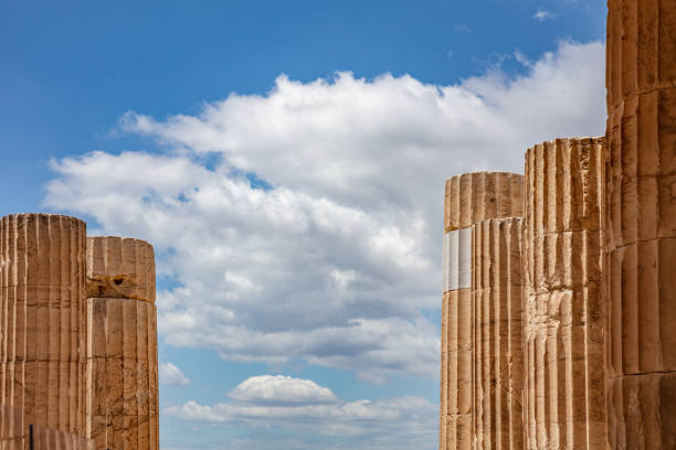 Athens Acropolis, Greece landmark. Ancient Greek columns pillars at Propylaea entrance gate closeup view blue cloudy sky, sunny spring day.